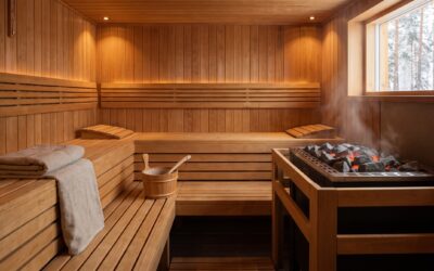 Warm traditional Finnish sauna interior with cedar benches and a heater topped with glowing rocks and steam
