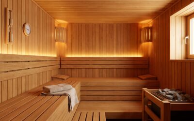 Traditional sauna interior with a wall-mounted sand timer and thermometer beside cedar benches